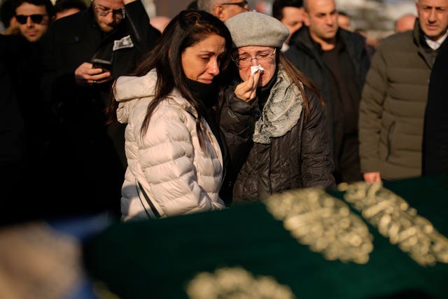 Relatives mourn over the coffin of Nedim Turkmen