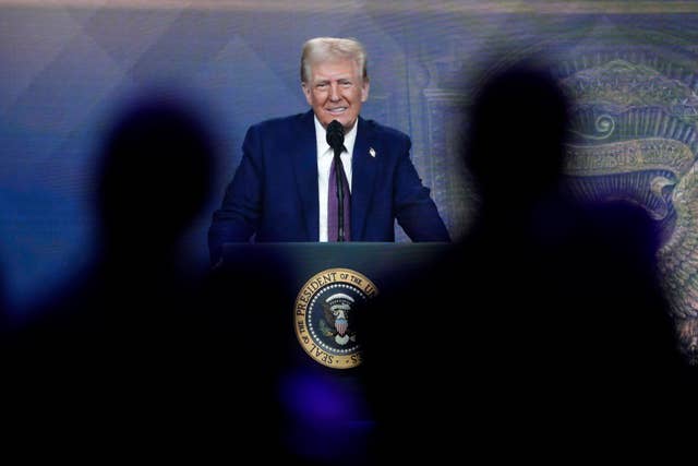 Donald Trump speaks from a podium with the US presidential seal