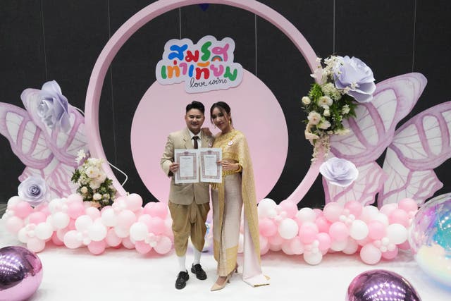 A couple from the LGBTQ+ community show their marriage certificate in Bangkok, Thailand