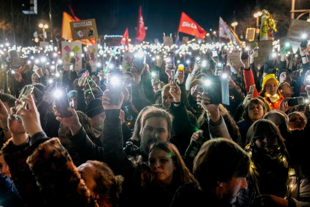 Protesters hold up their phones