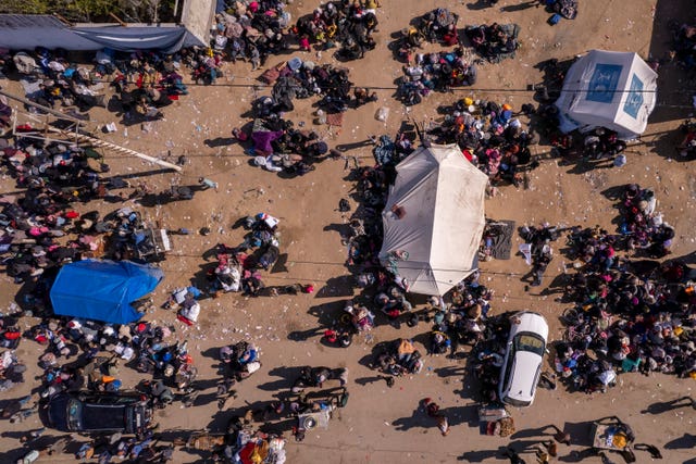 Aerial photograph taken by a drone shows displaced Palestinians gathering with their belongings near a roadblock