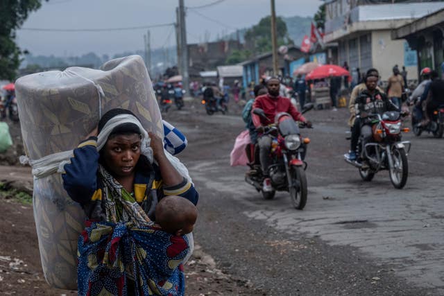 Child carries baby in a sling and a bed on their back