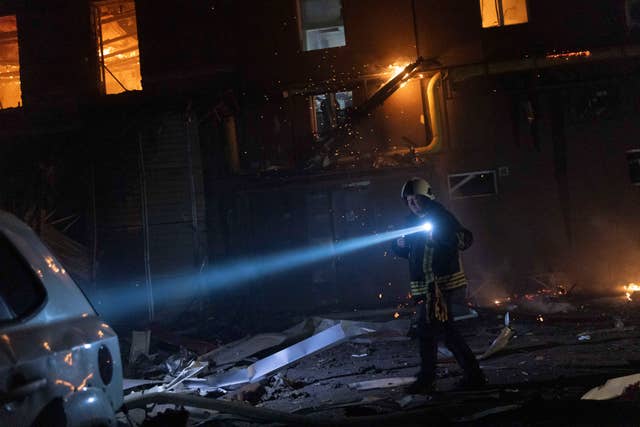 Firefighters extinguish a fire after a Russian attack on a civil factory in Kharkiv