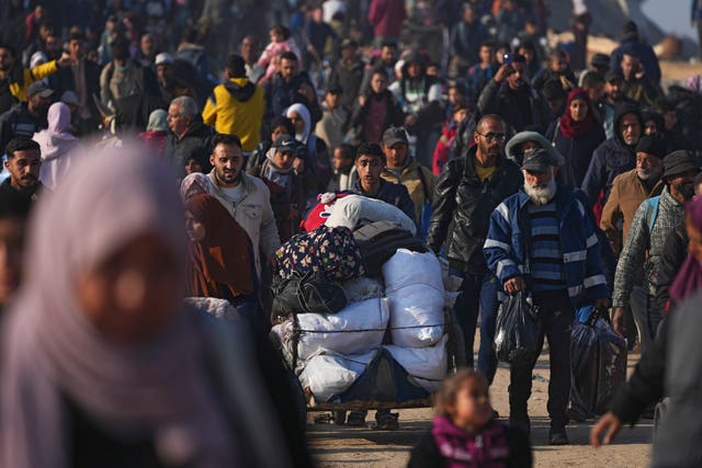 Displaced Palestinians walk on a road to return to their homes in the northern Gaza Strip