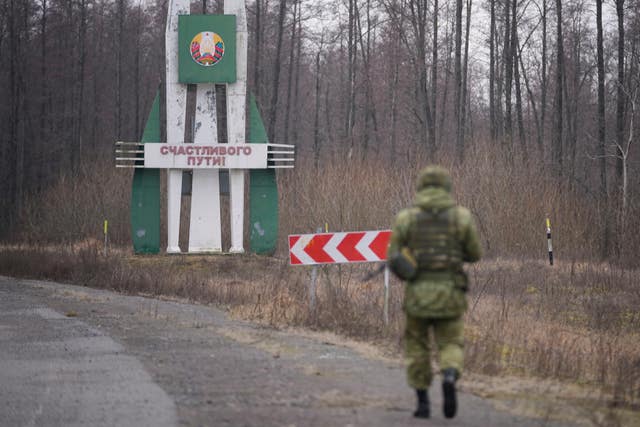 A Belarusian border guard inspects a road from Belarusian border checkpoint Novaya Guta to Ukrainian border checkpoint Novy Yarylovychi