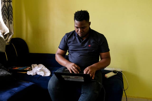 Ugandan human rights activist Kennedy Pius reads a letter from USAid on his laptop