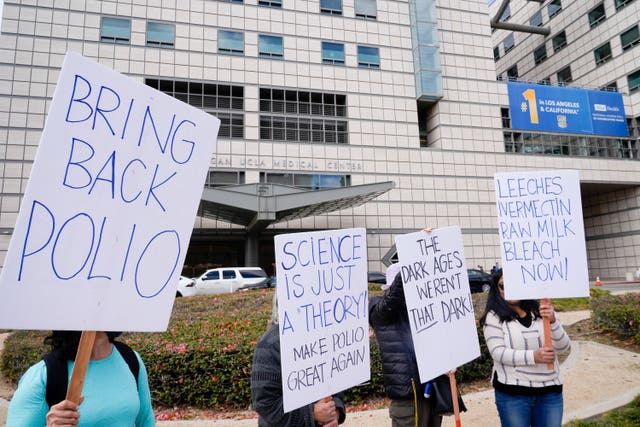 Demonstrators hold signs protesting against the nomination of Robert F. Kennedy Jr to be health secretary 