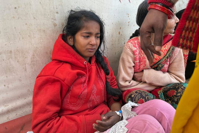 An injured girl reacts as she is being treated at a hospital after a stampede 