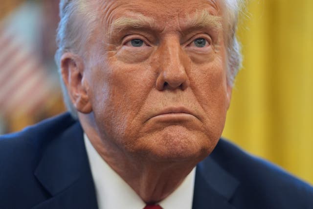 President Donald Trump listens to a question as he signs executive orders in the Oval Office at the White House