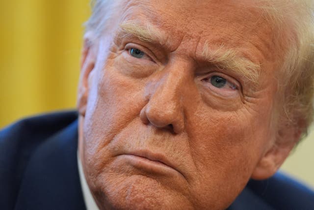 President Donald Trump listens to a question as he signs executive orders in the Oval Office at the White House