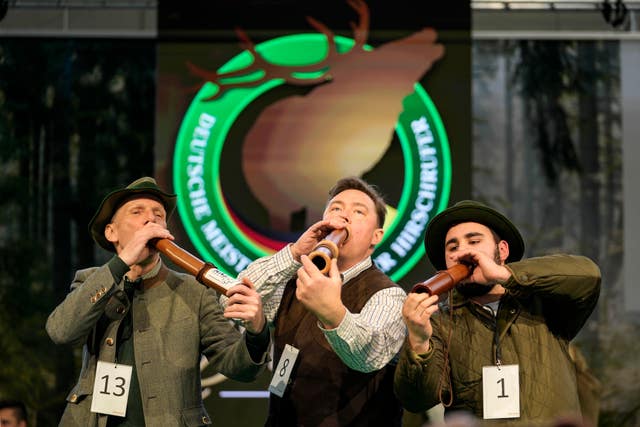 Winner Fabian Menzel, center, 2nd placed Thomas Soltwedel, left, and 3rd placed Jerome Boehm perform to imitate a stag in heat 