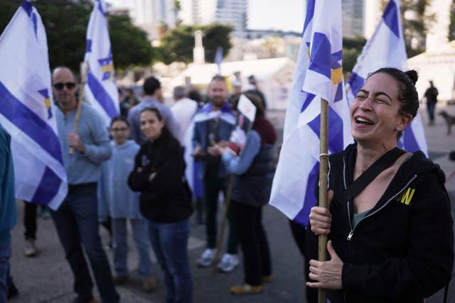 Israelis react as they watch a broadcast of the release of American-Israeli Keith Siegel,