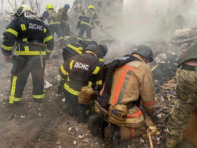 Rescue workers inspect a smoking crater in Ukraine