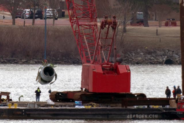 Salvage crews pull up a plane engine