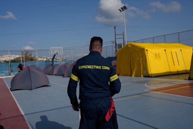 A firefighter walks next to tents set up at a basketball court to accommodate Fire Service rescuers