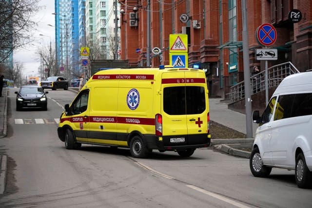 An ambulance drives away from the site