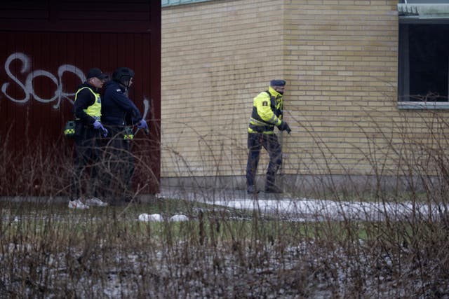 Armed police officers next to wall