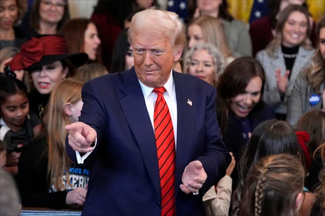 President Donald Trump gestures after signing an executive order barring transgender female athletes from competing in women’s or girls’ sporting events, in the East Room of the White House