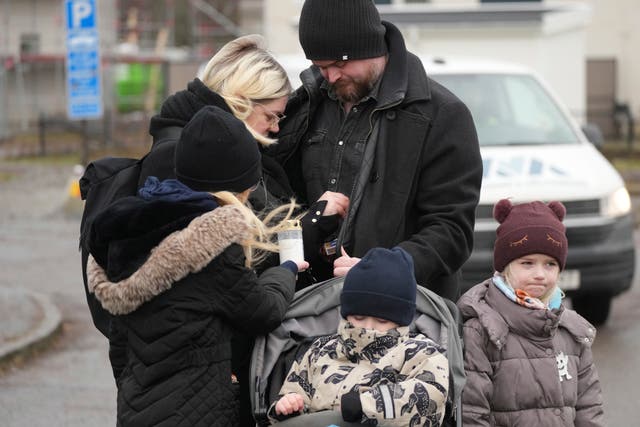 People light candles at a makeshift memorial near the scene of a shooting on the outskirts of Orebro, Sweden 