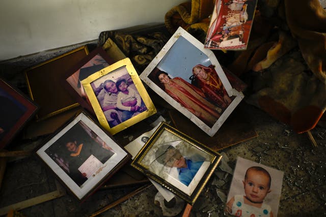 Family photographs on the floor in a room of a vandalised property