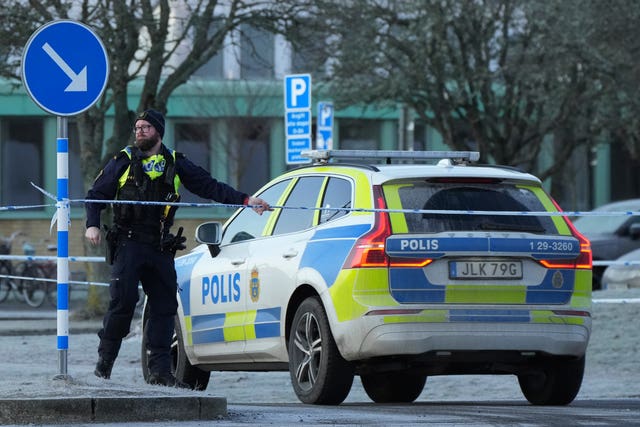 Police officer stands next to police car