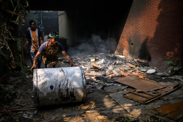 People walking around a destroyed property