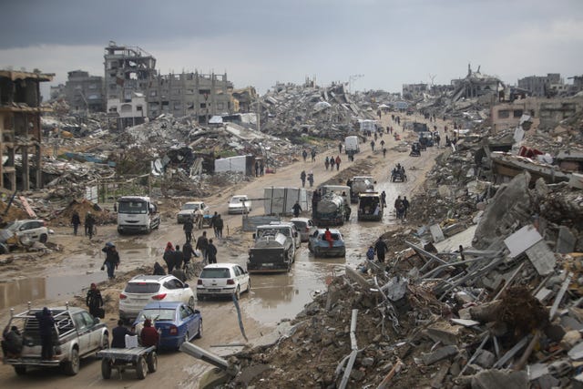 Traffic moves along a road in Gaza amid scenes of devastation