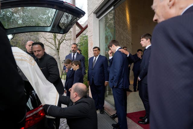 Prince Rahim Al-Hussaini watches with his children as the coffin is placed in a hearse