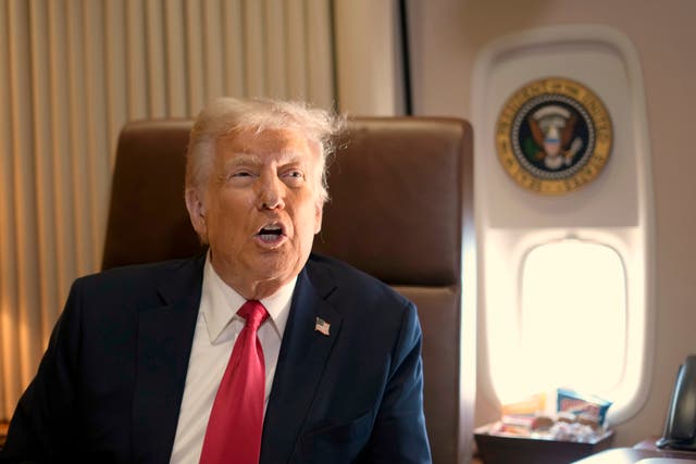 President Donald Trump speaks to reporters aboard Air Force One 