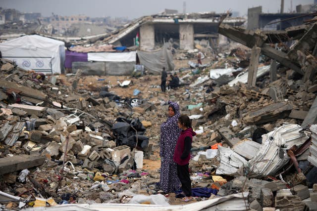 A family in the ruins of their home amid widespread destruction caused by the Israeli military’s ground and air offensive in Gaza