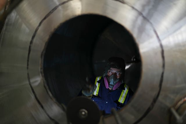 An employee works on a container at a steel tank factory in Mexico City