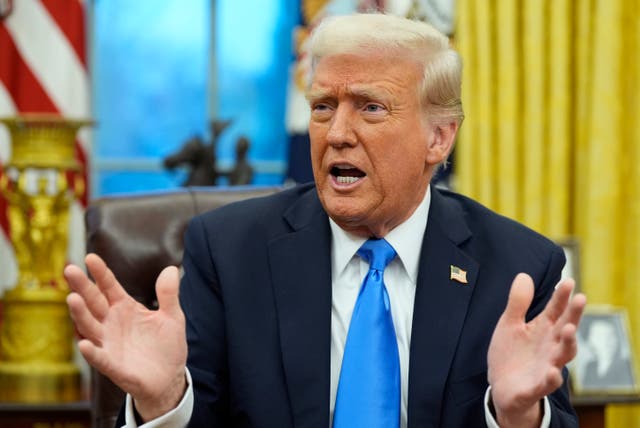 President Donald Trump gestures while speaking to reporters in the Oval Office 