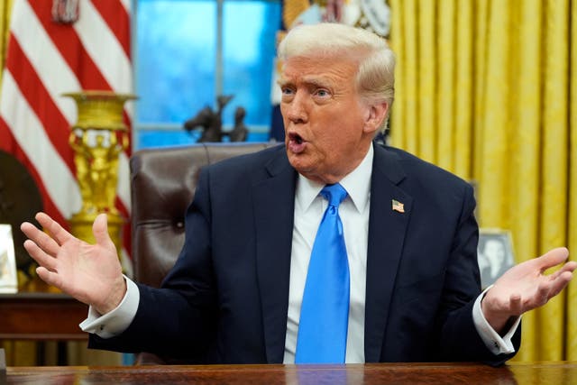 President Donald Trump gestures while speaking to reporters in the Oval Office