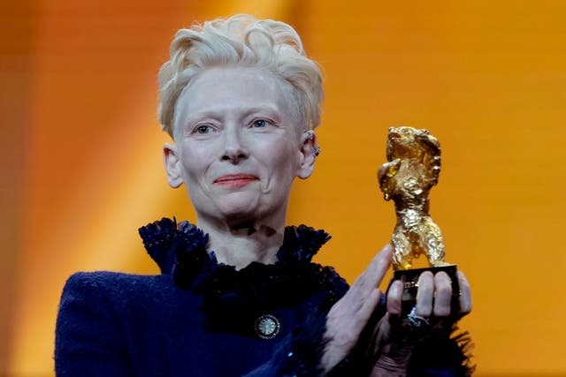 Tilda Swinton holding a golden bear award