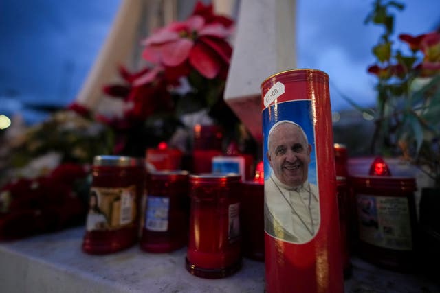 Candles, one showing a photo of Pope Francis, in front of the Agostino Gemelli Polyclinic in Rome