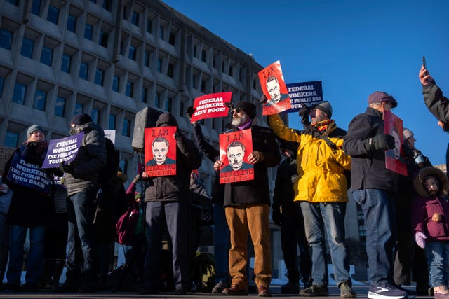 Demonstrators rally in support of federal workers outside of the Department of Health and Human Services,