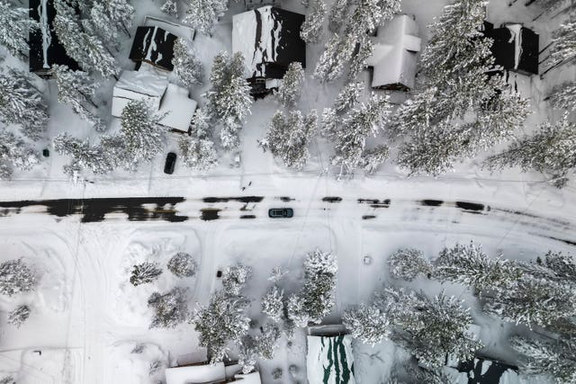 View from above of snow-covered homes, surrounded by trees