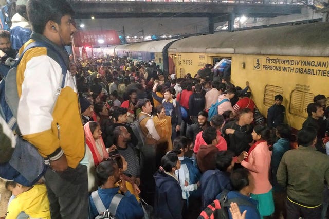 People jostle to board a train in New Delhi