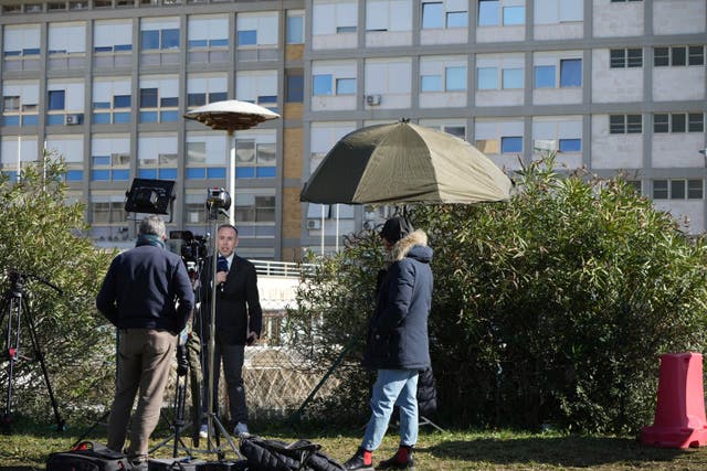 Journalists report outside a building