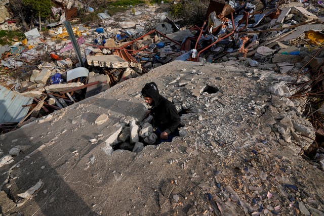 A man stands in the remains of his house in the southern Lebanese town of Kfar Kila