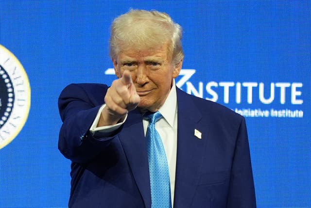 Donald Trump points at the audience as he arrives for a speech in Miami