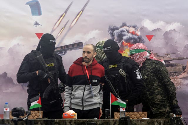 Israeli hostage Tal Shoham escorted by Hamas fighters