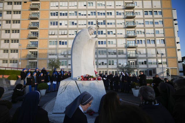 Nuns and priests pray for Pope Francis at a hospital in Rome