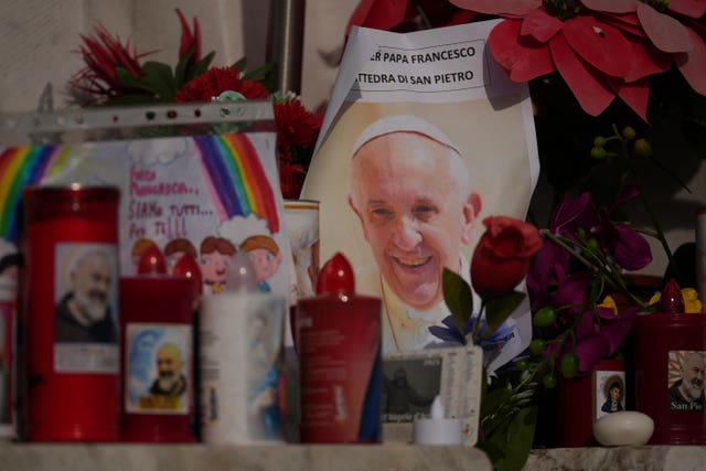 An image of Pope Francis is seen among candles in front of the Agostino Gemelli Polyclinic, in Rome