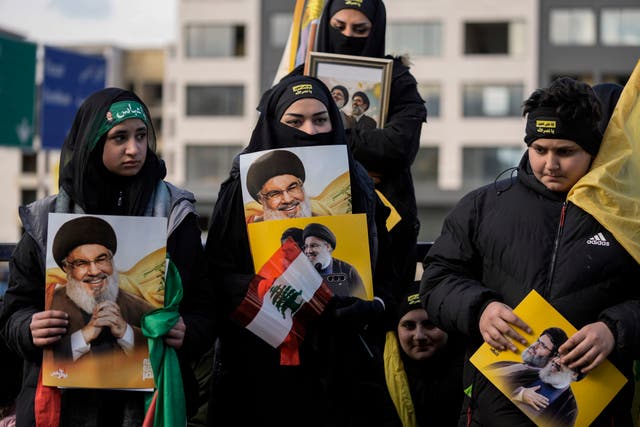 Mourners hold pictures of Hassan Nasrallah and Hashem Safieddine 