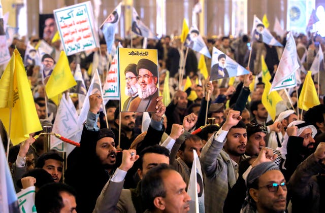 Mourners wave flags and posters 