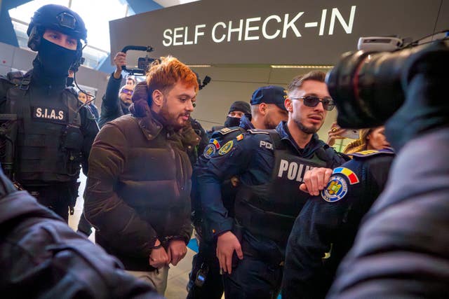 Mohamed Amra being escorted by armed police officers