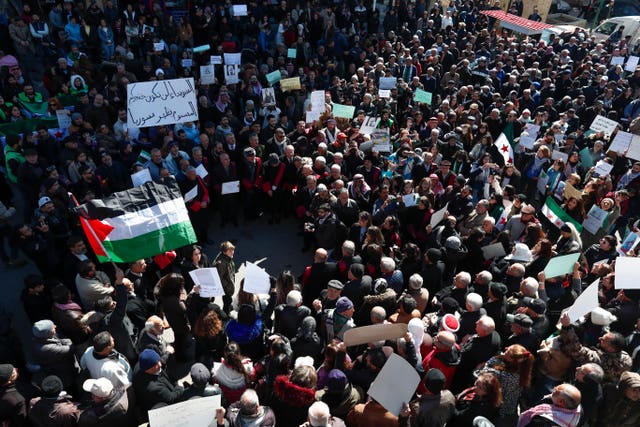 Syrian Druze hold up a placard in Arabic reading 'Sweida will not be your poisoned dagger in Syria’s back' at a demonstration