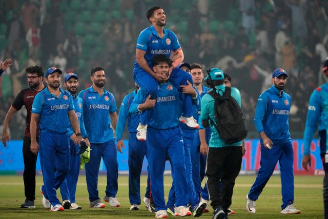 Afghanistan’s Azmatullah Omarzai, center on shoulder, and teammates celebrate 