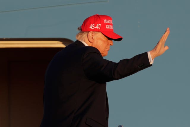 Side view of Donald Trump waving outside aircraft